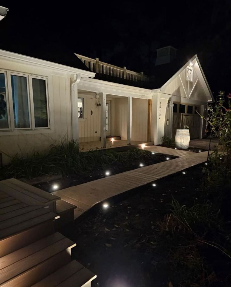 A white house with a walkway leading to it at night