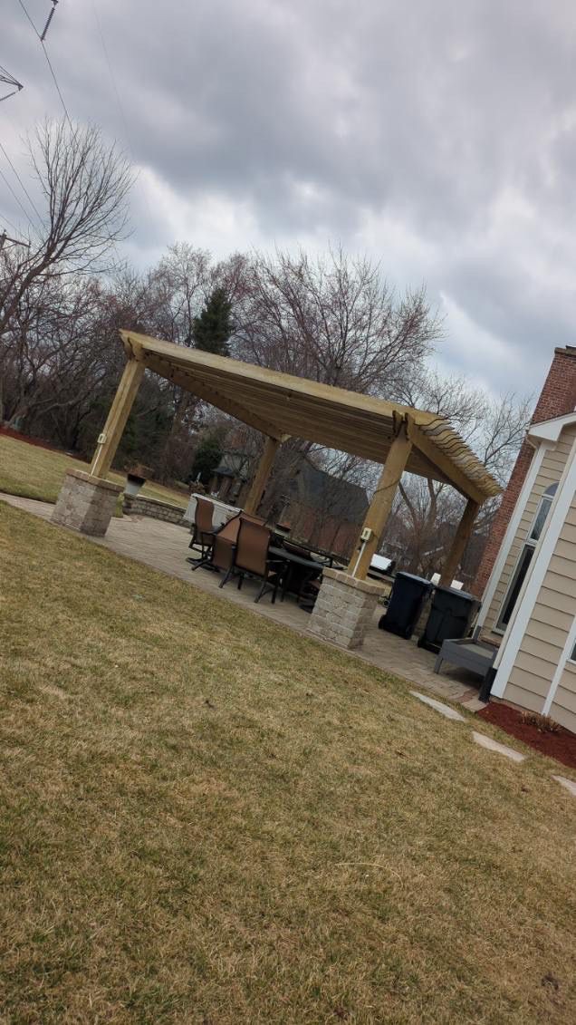 There is a pergola in the backyard of a house.