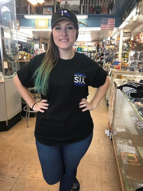 'We Got Your Six' shirt, and '1*' hat