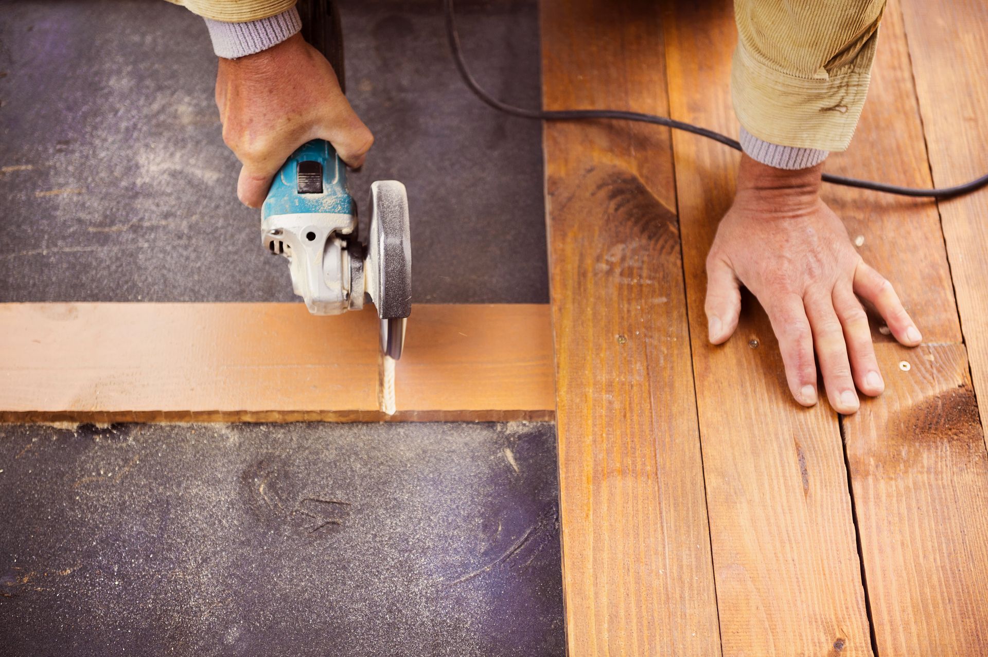 A person is cutting a piece of wood with a circular saw.