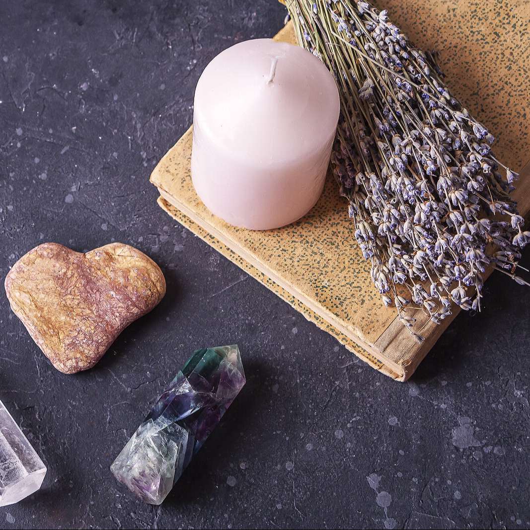 candle, healing crystals and herbs