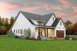 Modern white house with gray roof, front porch, garage, and landscaped lawn at sunset
