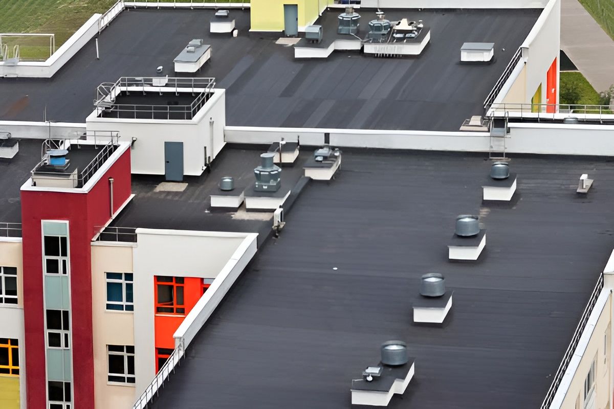 Buildings with flat, black roofs; rooftop equipment and colorful building facades.