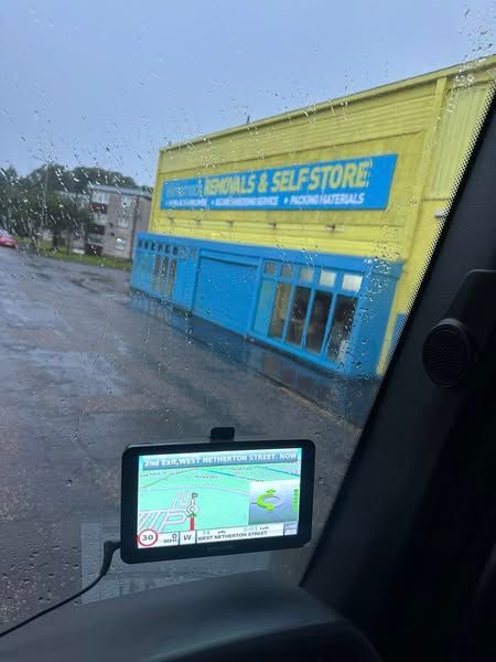 GPS screen in car; bright yellow and blue building with