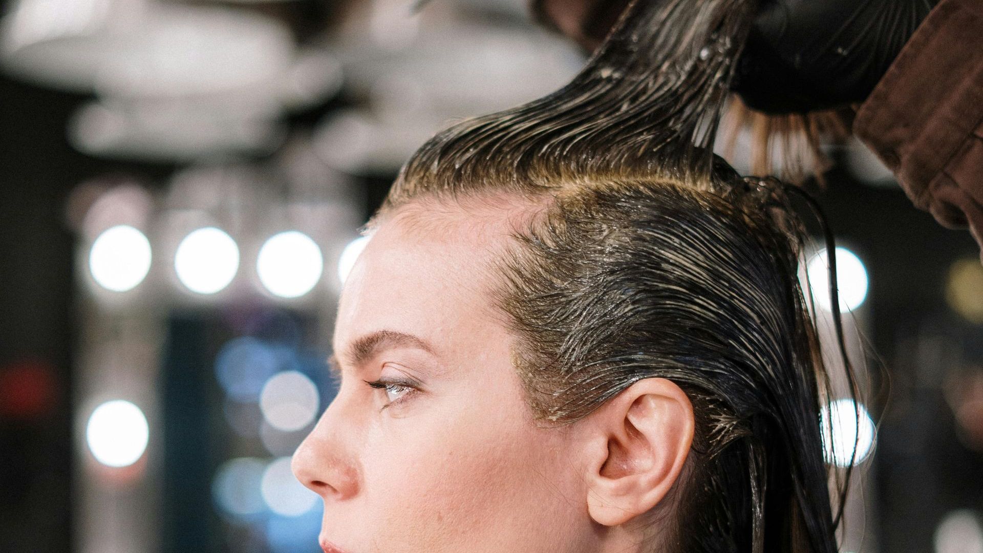 A woman is getting her hair dyed at a salon.