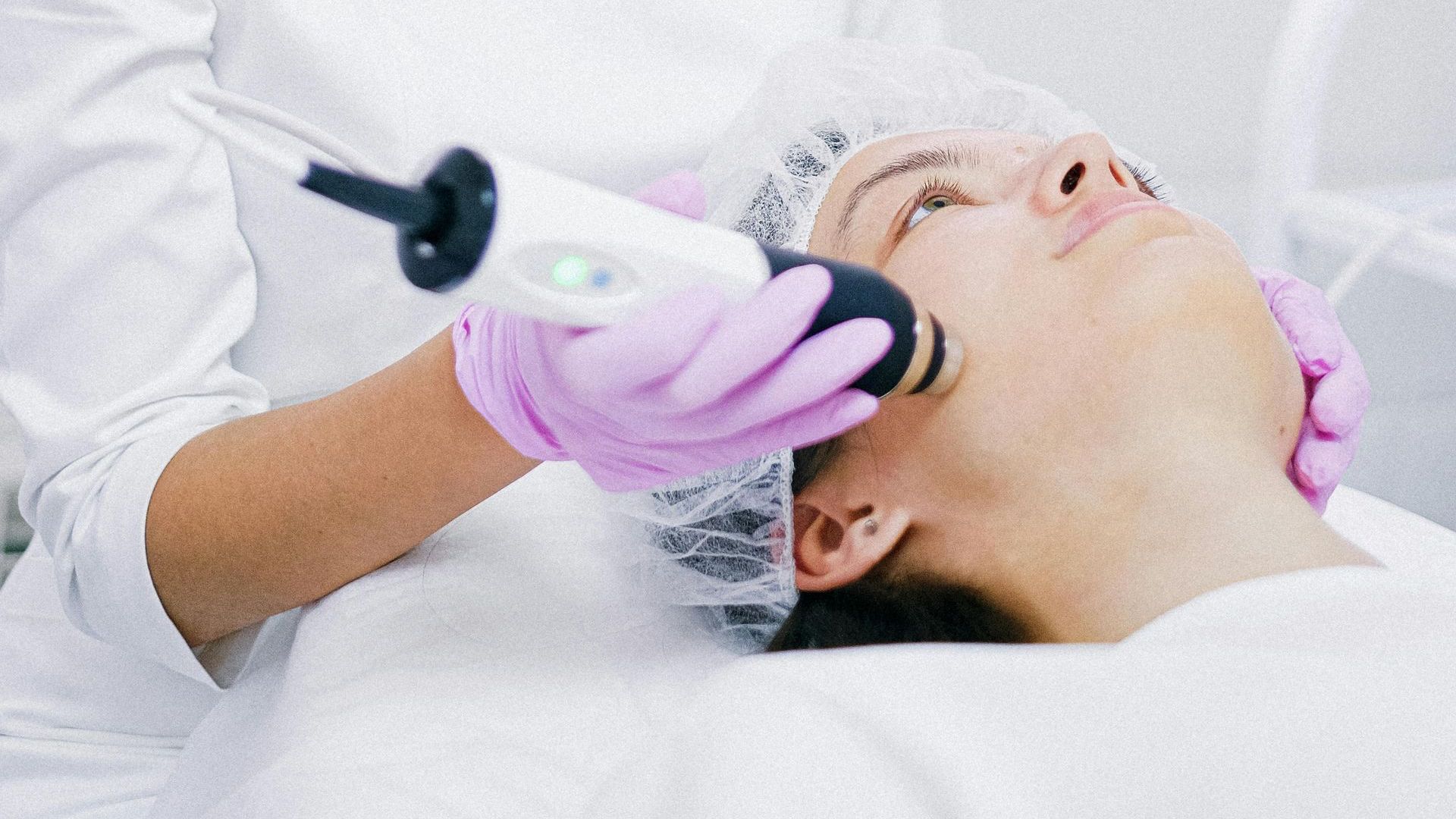 A woman is giving a woman a facial treatment in a beauty salon.