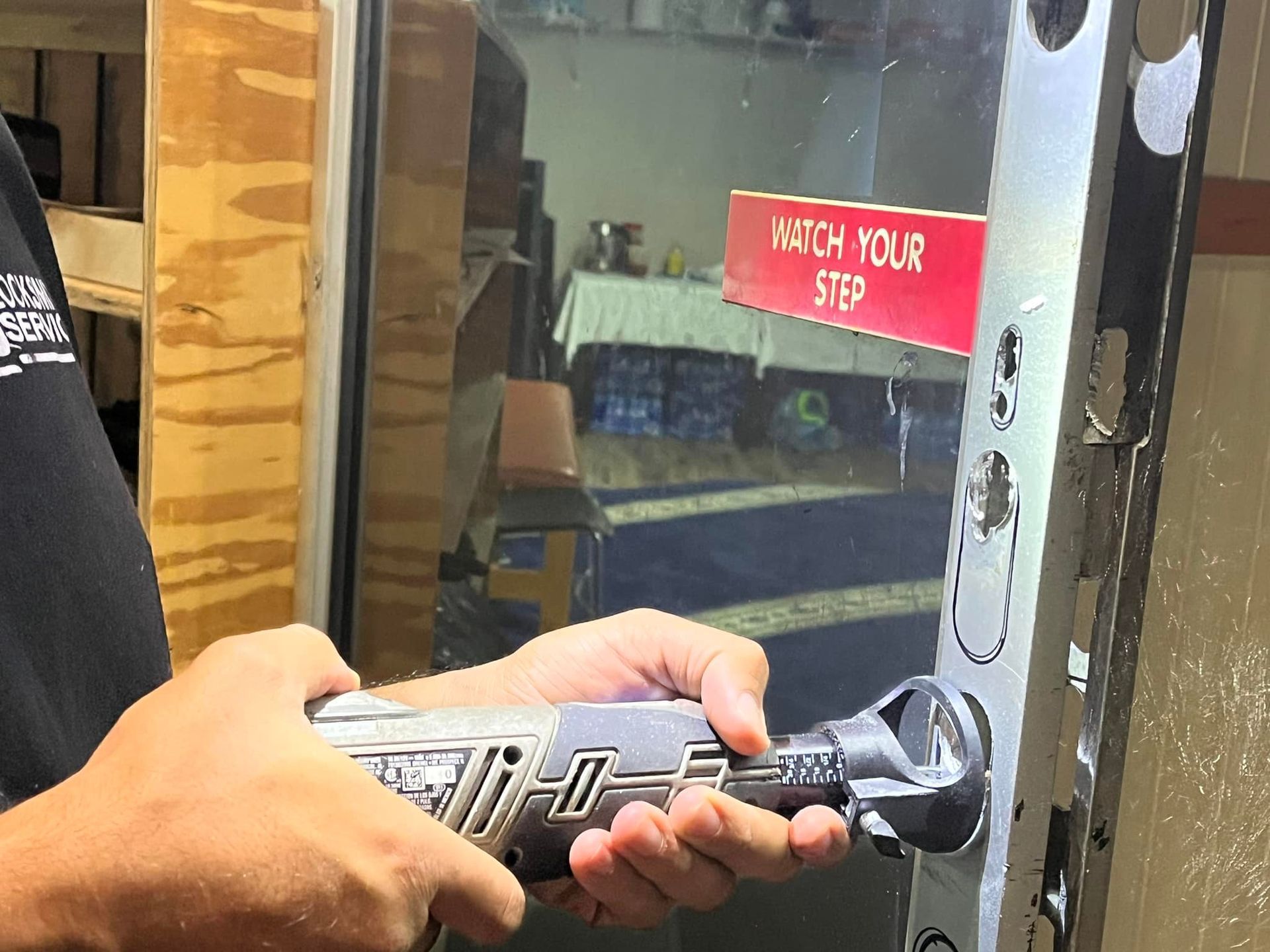 Person using a power tool to work on a door frame.