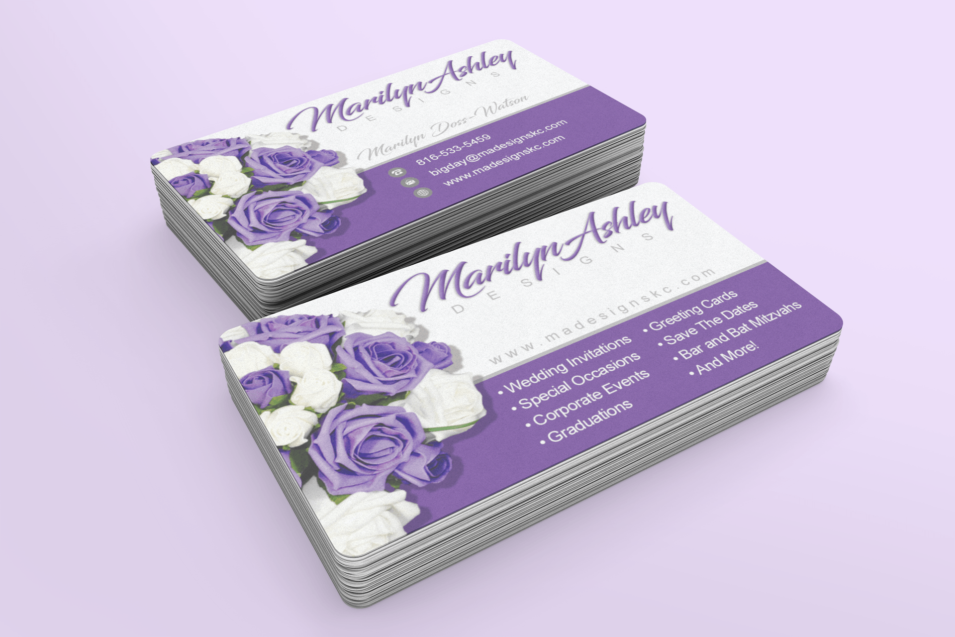 A stack of business cards with purple and white roses on them.