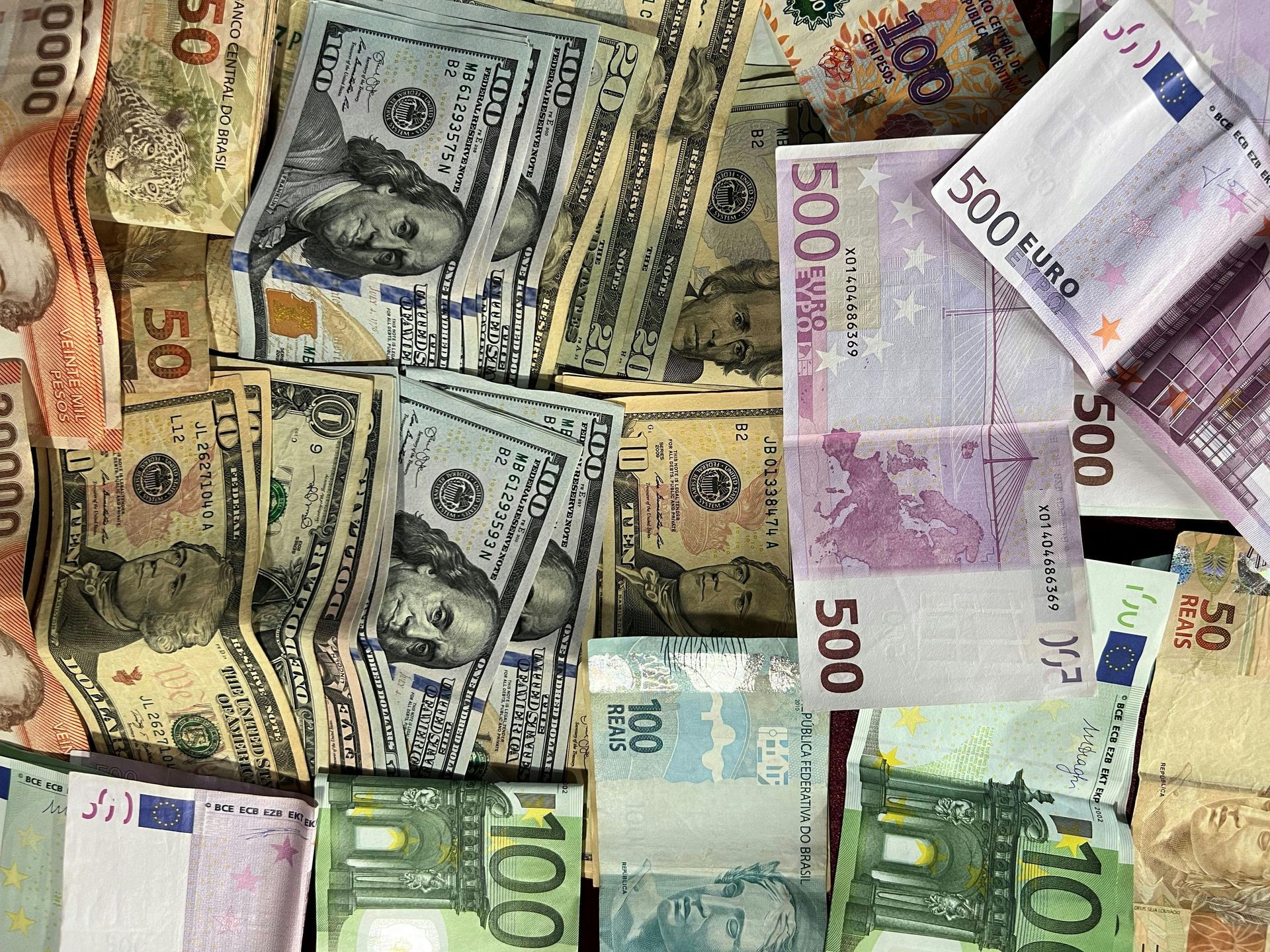 A pile of different currencies including dollars and euros