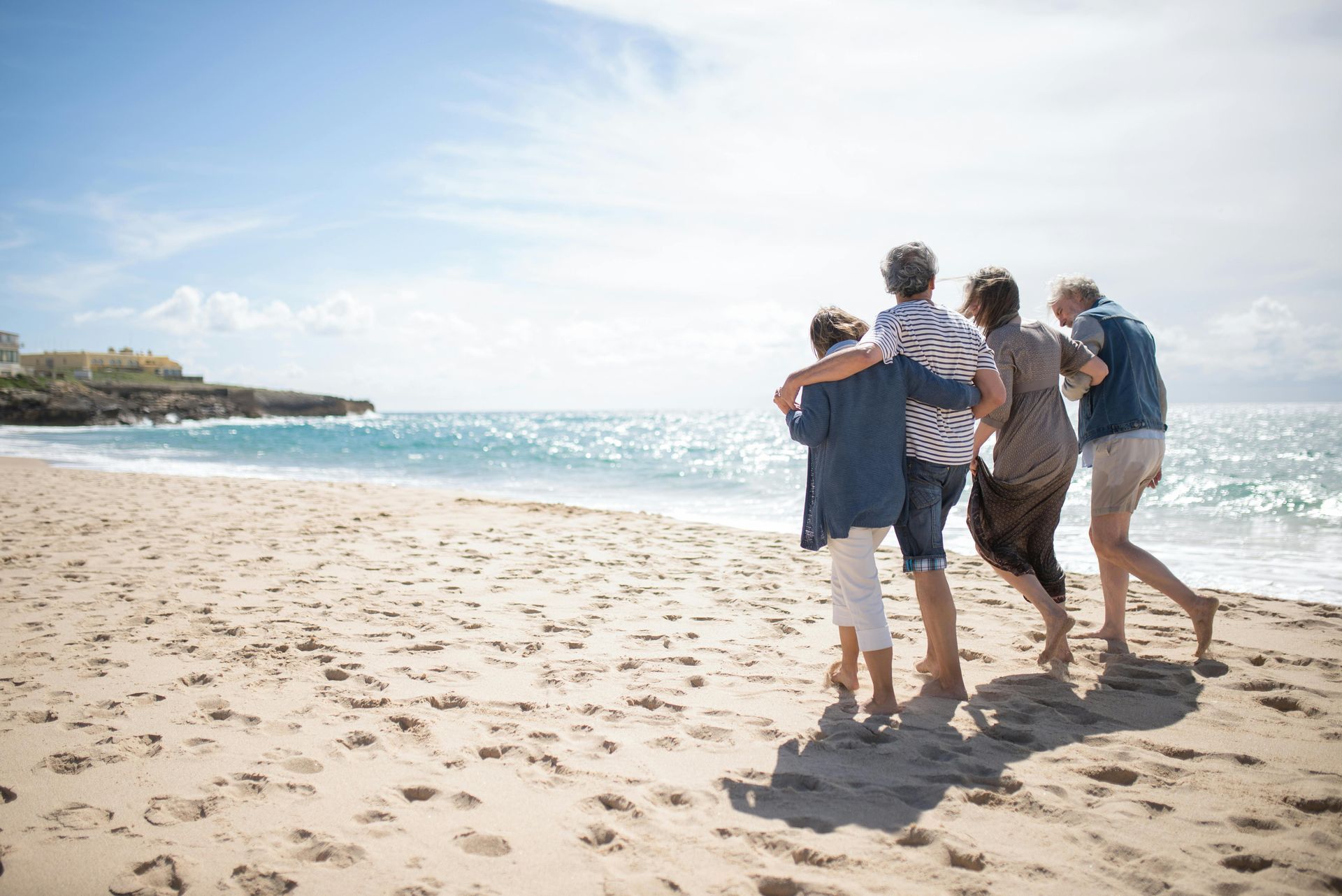 A group of people are walking on a beach.