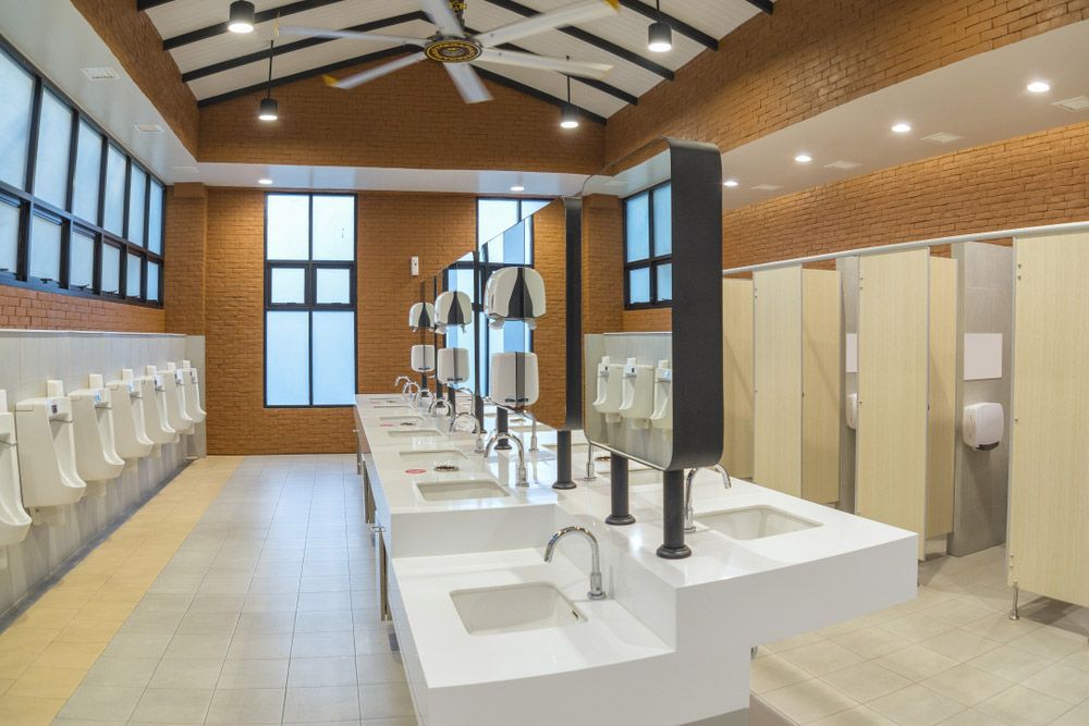 A Public Restroom With a Lot of Sinks and Urinals — Hey Presto Kitchens & Renovations in Armidale, NSW