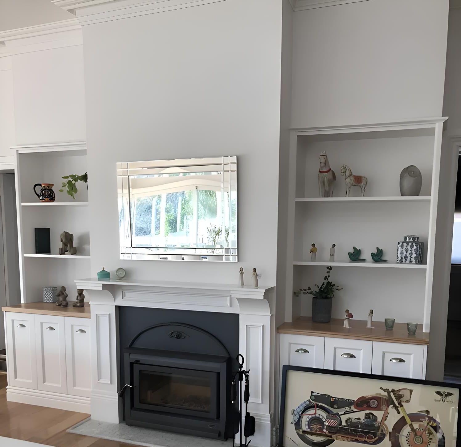 A living room with a fireplace and a picture of a motorcycle — Hey Presto Kitchens & Renovations in Armidale, NSW