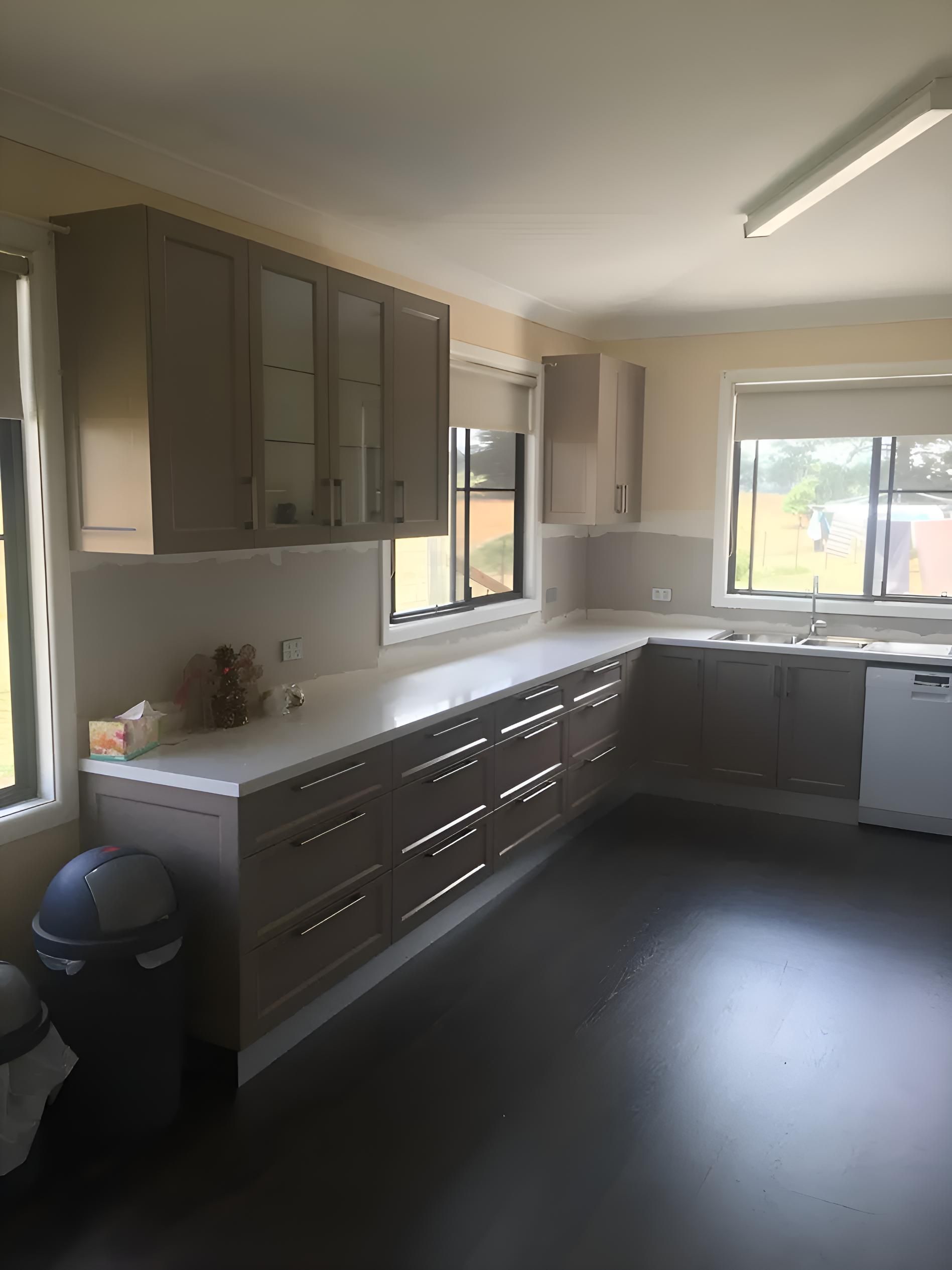A Kitchen With A Lot Of Cabinets , A Sink , And A Trash Can — Hey Presto Kitchens & Renovations in Uralla, NSW