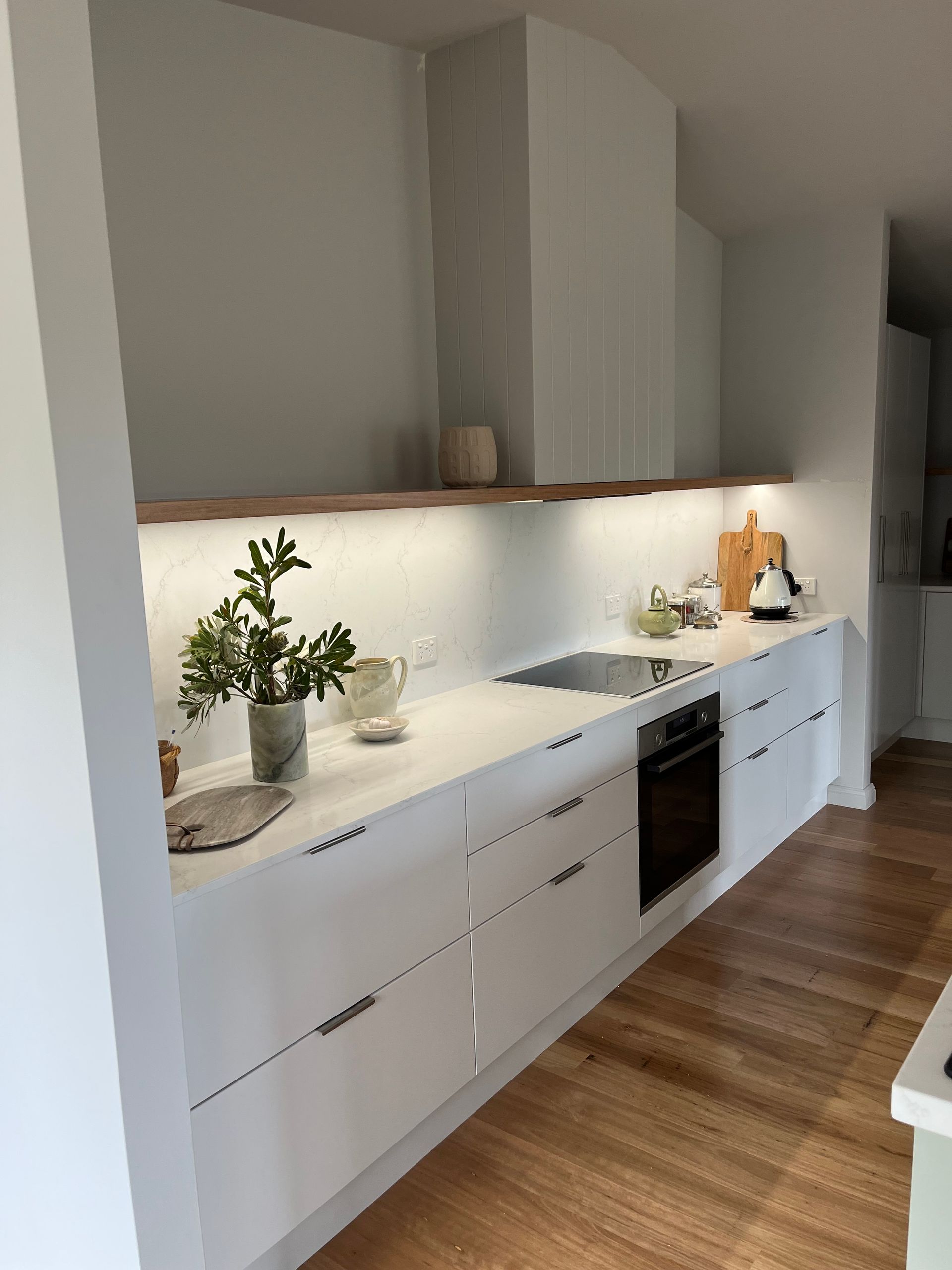 A long white counter in a kitchen with a stovetop — Hey Presto Kitchens & Renovations in Armidale, NSW