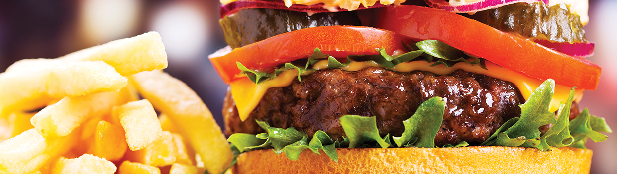 A close up of a hamburger and french fries on a table.