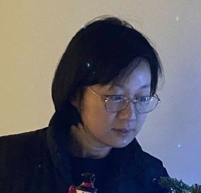 A man wearing glasses and a suit is smiling for the camera.