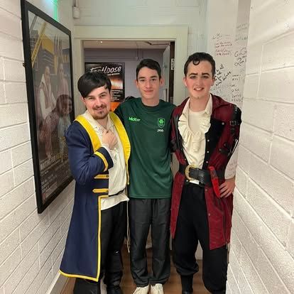 Three men in pirate costumes are posing for a picture in a hallway.