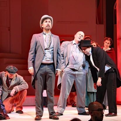 A group of men in suits and hats are standing on a stage.