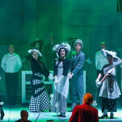 A group of people in costumes are standing on a stage.