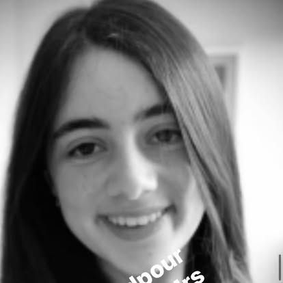 A woman with long hair is smiling in a black and white photo.