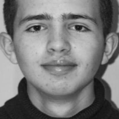 A close up of a young man 's face in a black and white photo.