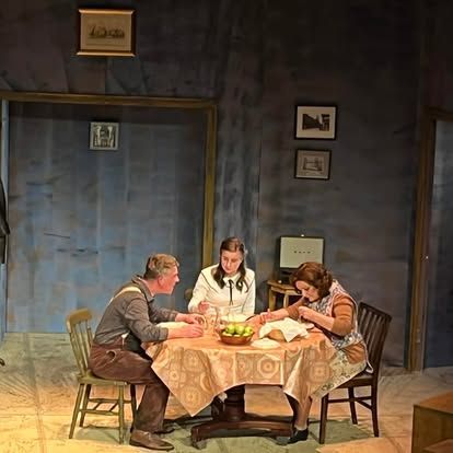 A group of people are sitting around a table in a room.