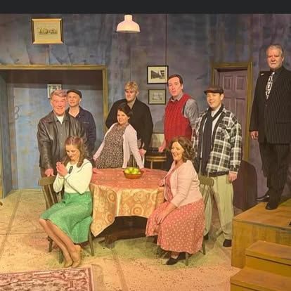 A group of people are standing around a table in a room.