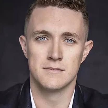 A close up of a man 's face wearing a suit and white shirt.
