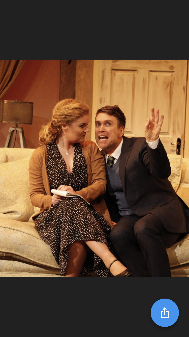 A man and a woman are sitting on a couch.