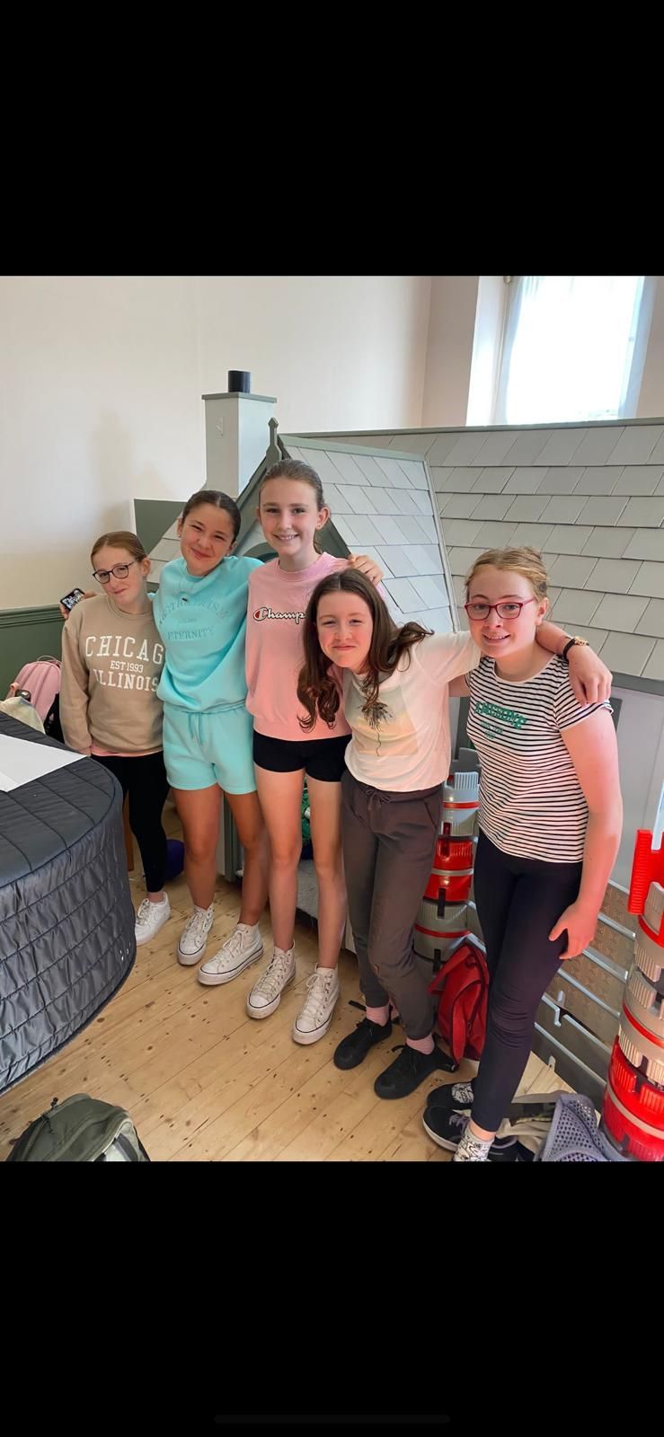 A group of people are posing for a picture while sitting in chairs.