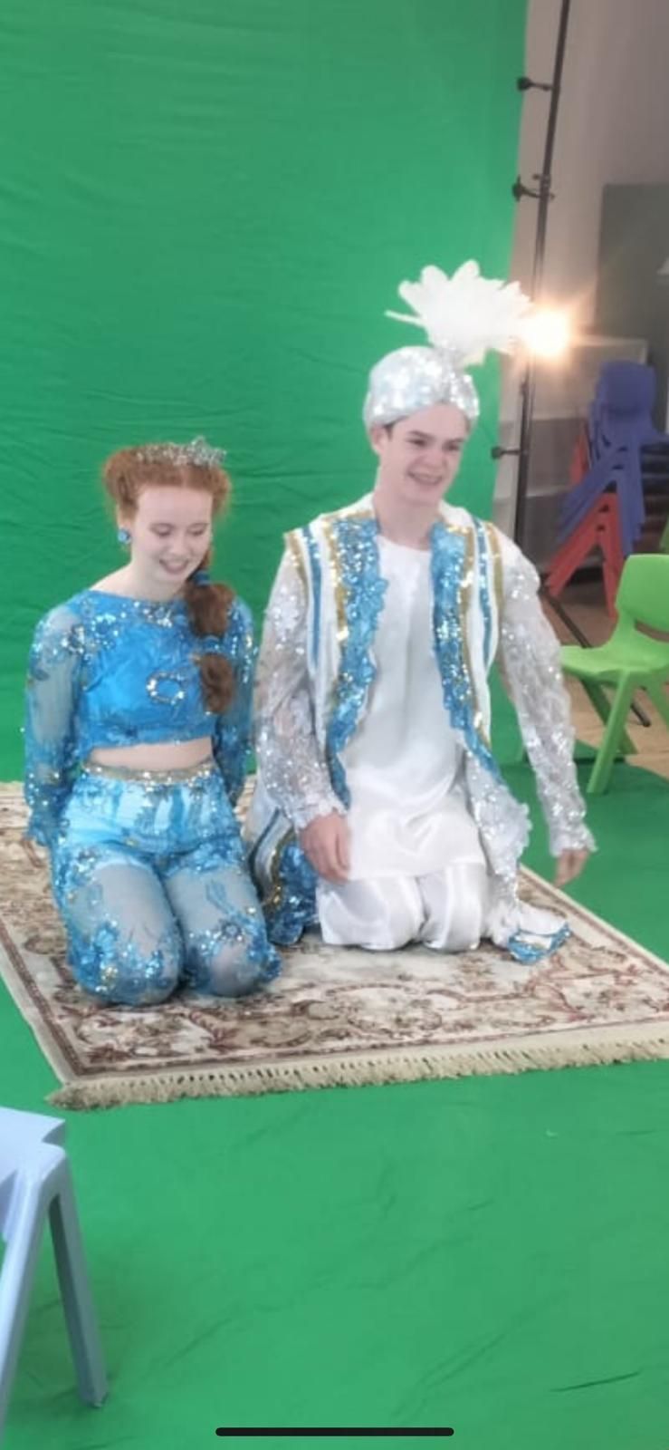 A group of children posing for a picture with a man in a military shirt