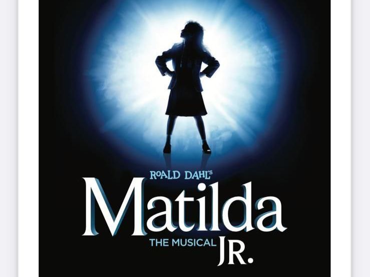 A group of people are standing around a woman in a red dress.