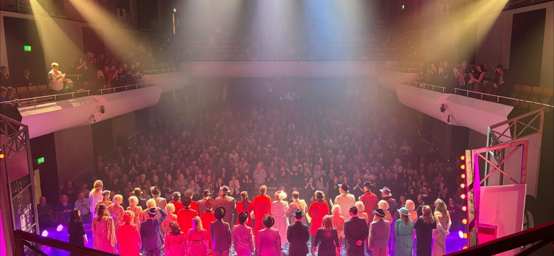 A large crowd of people are standing in a circle on a stage at a concert.