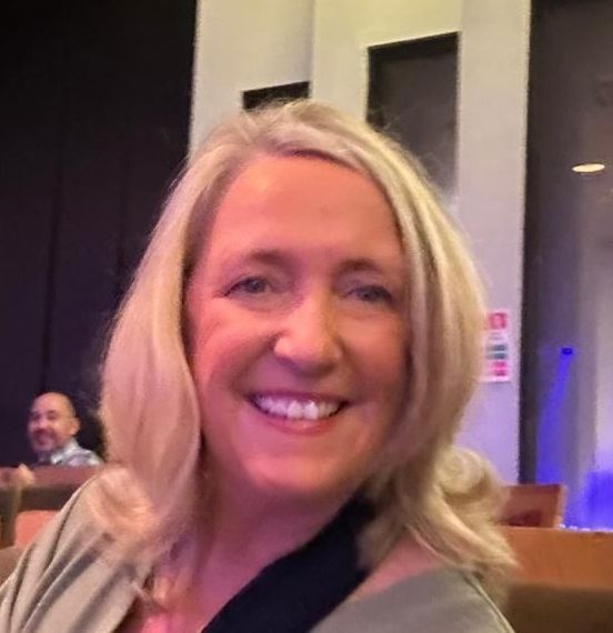 A woman with blonde hair is smiling for the camera