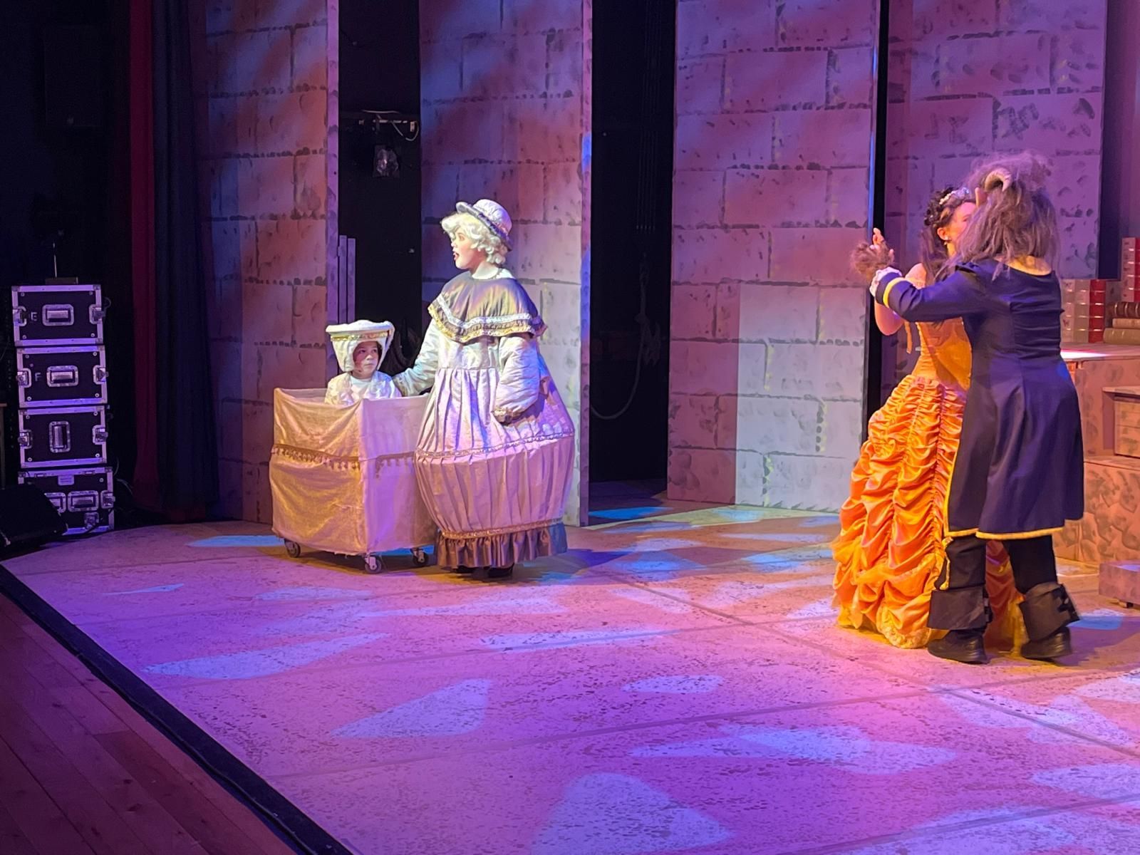 A group of people standing in a room wearing pink hoodies