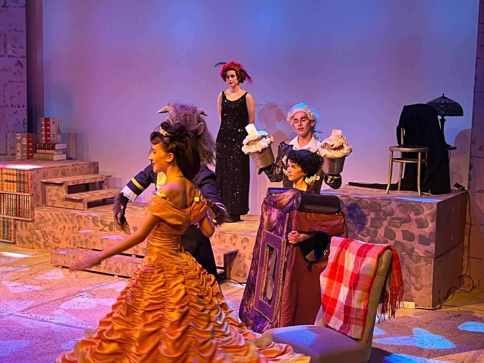 A group of people are sitting on the grass in front of a blackboard.