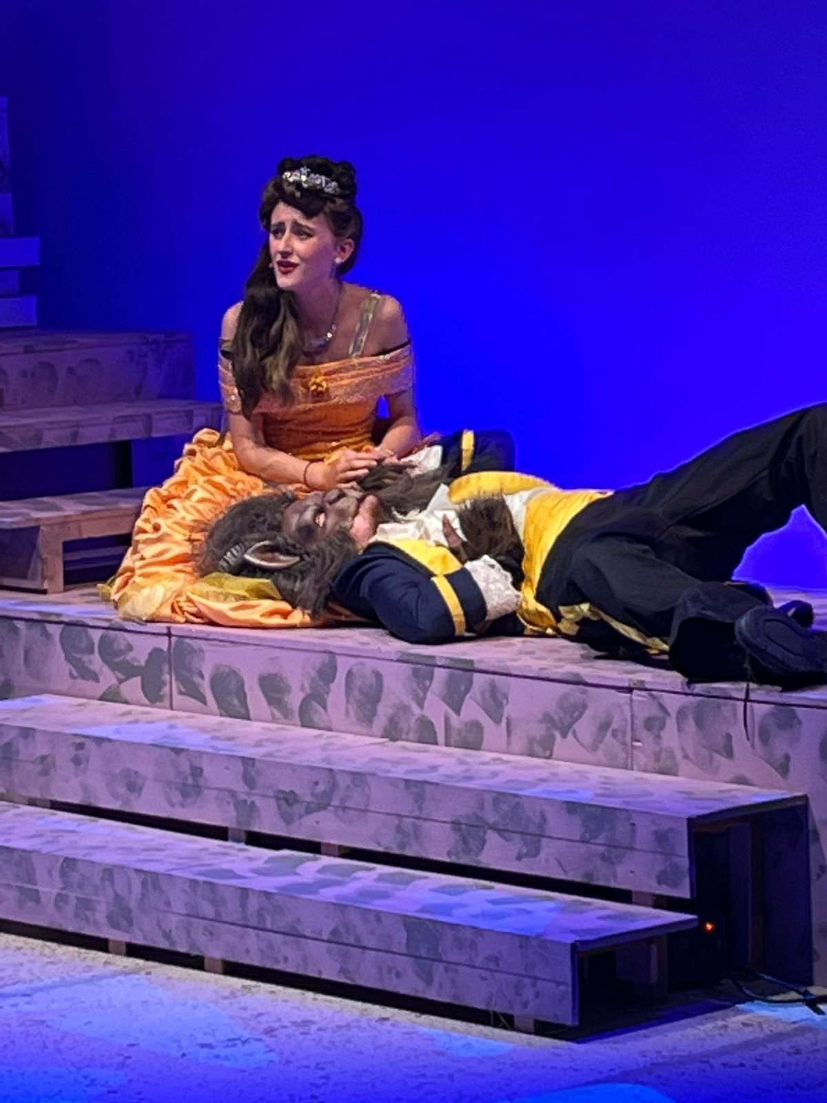A group of children posing for a picture with a man in a military shirt