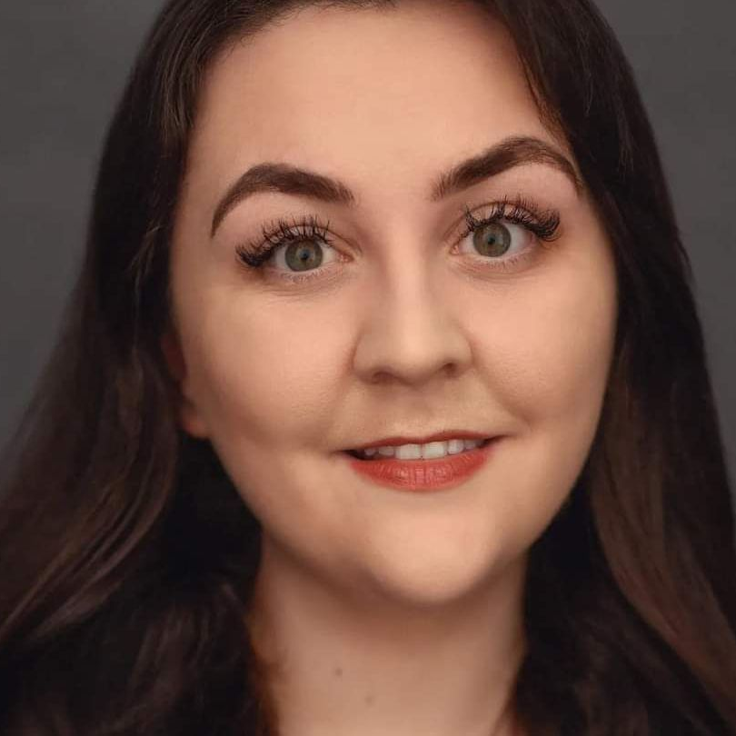A man with long hair and a beard is wearing a black shirt