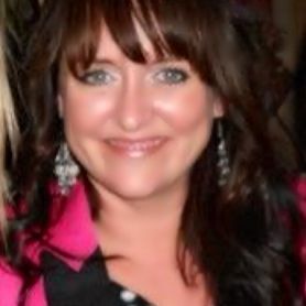 A man in a suit and tie is standing in front of a crowd.