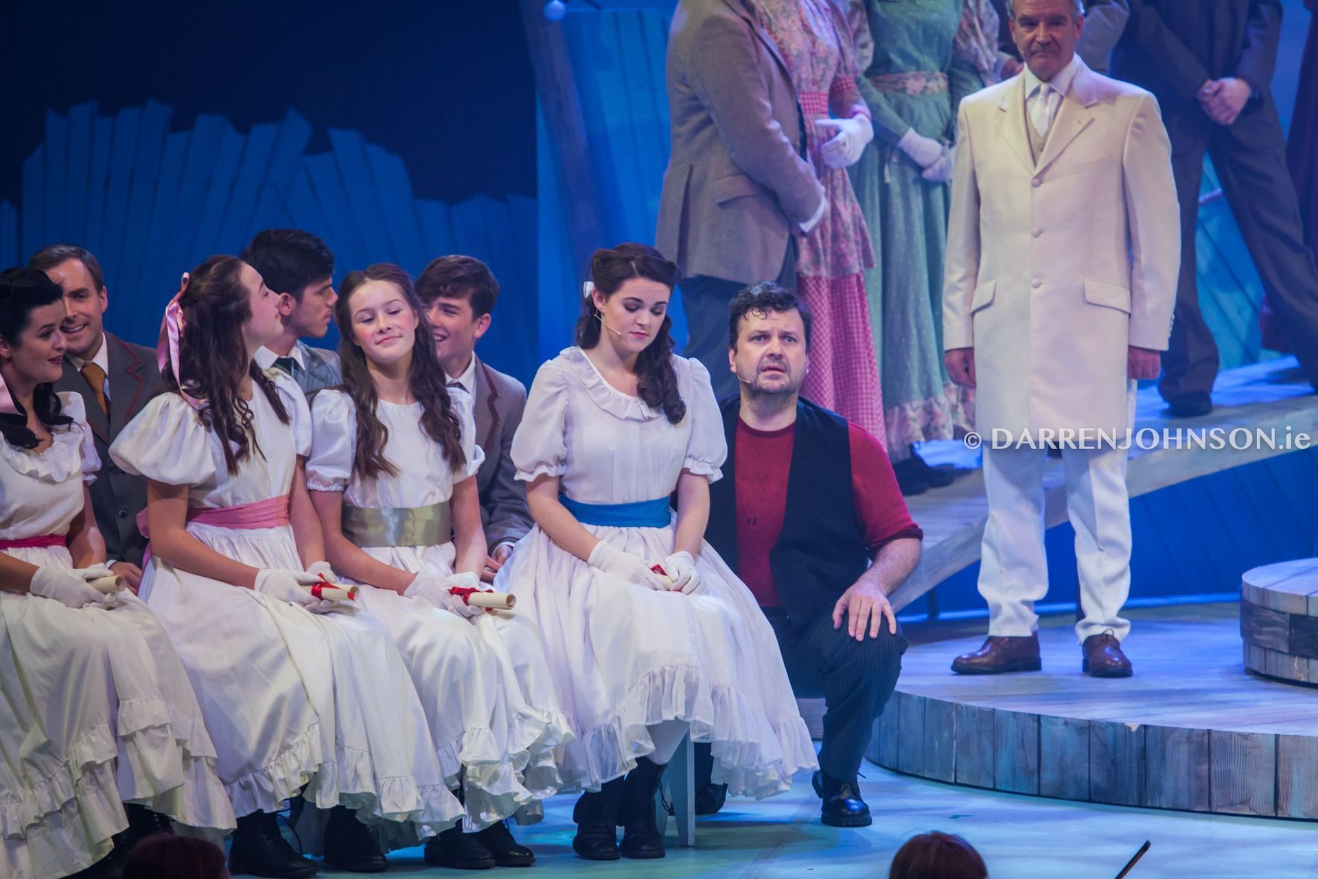 A group of people are sitting on a stage in a play.