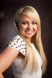 A man in a black sweater is sitting in front of a christmas tree