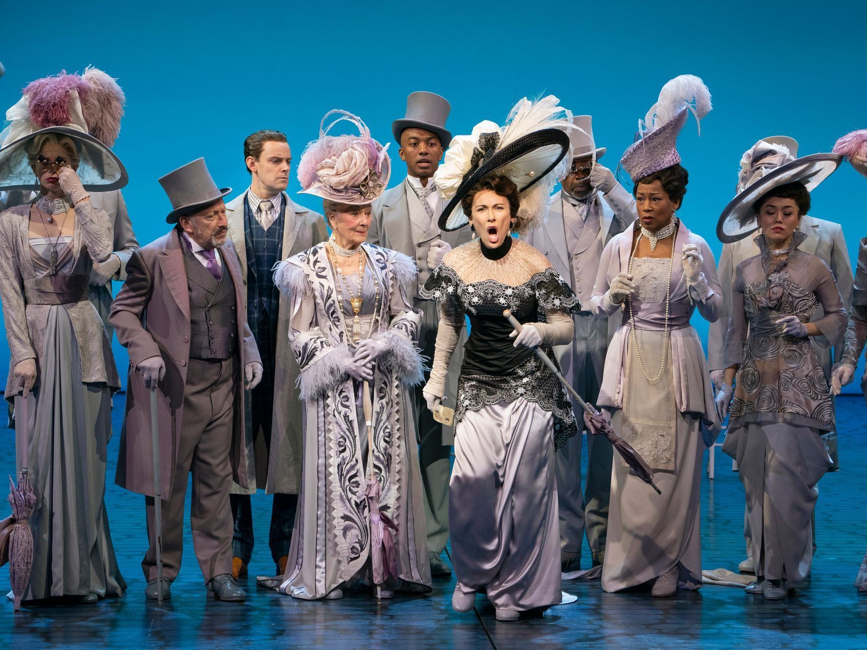 A group of people in costumes are standing on a stage.