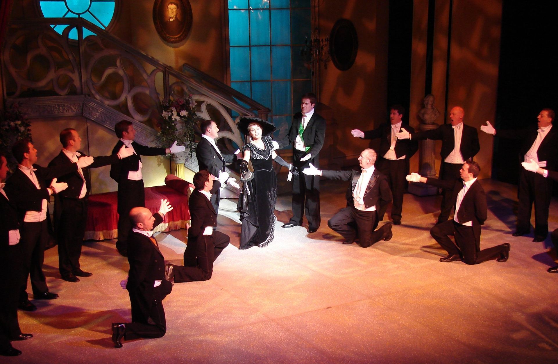 A group of men in tuxedos are on their knees on a stage