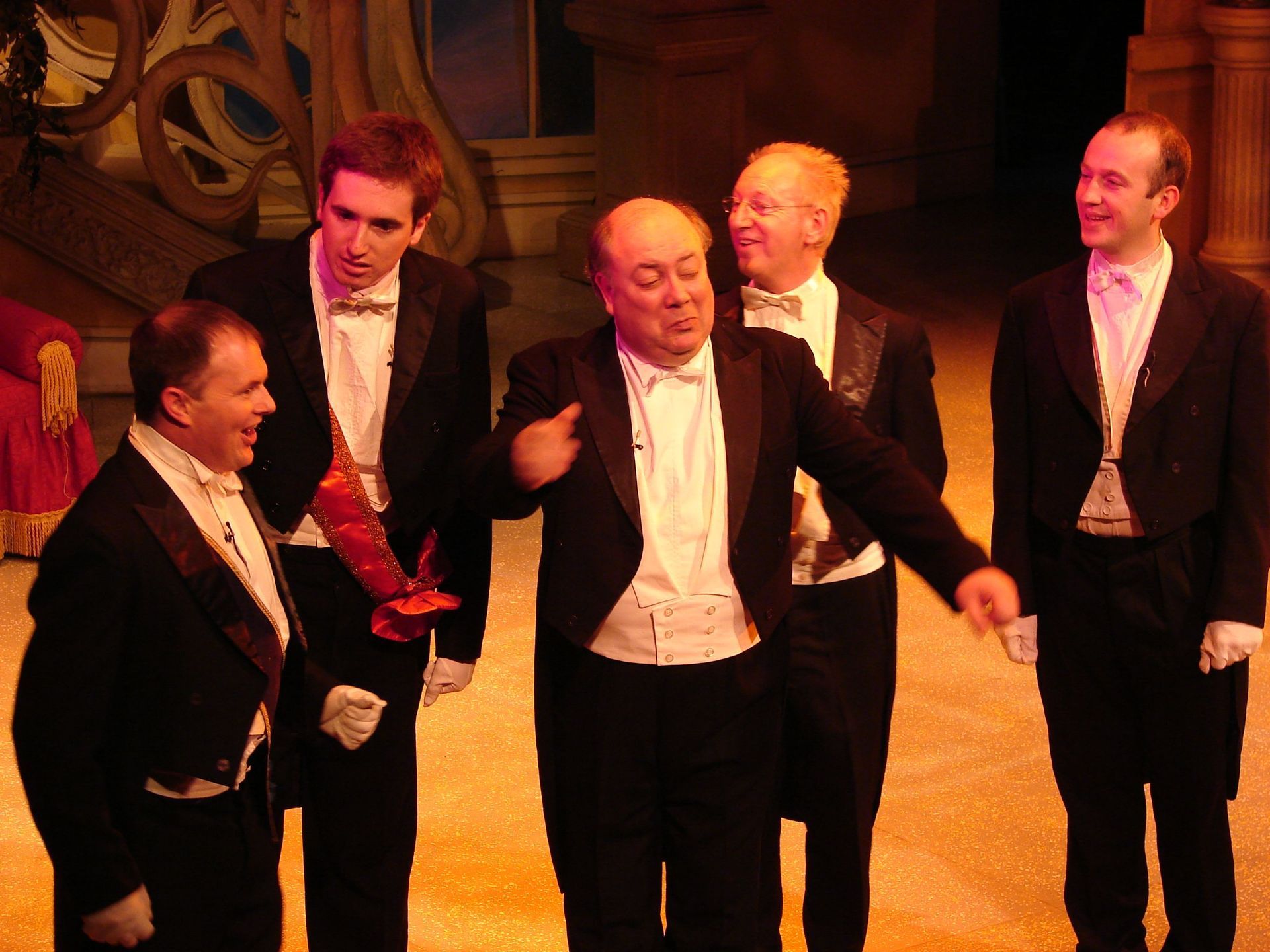 A group of men in tuxedos and bow ties on a stage