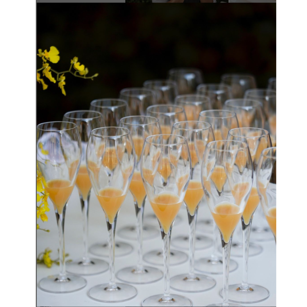 A Bunch Of Wine Glasses Filled With Orange Liquid — Wedding & Event Hire In Goonellabah, NSW
