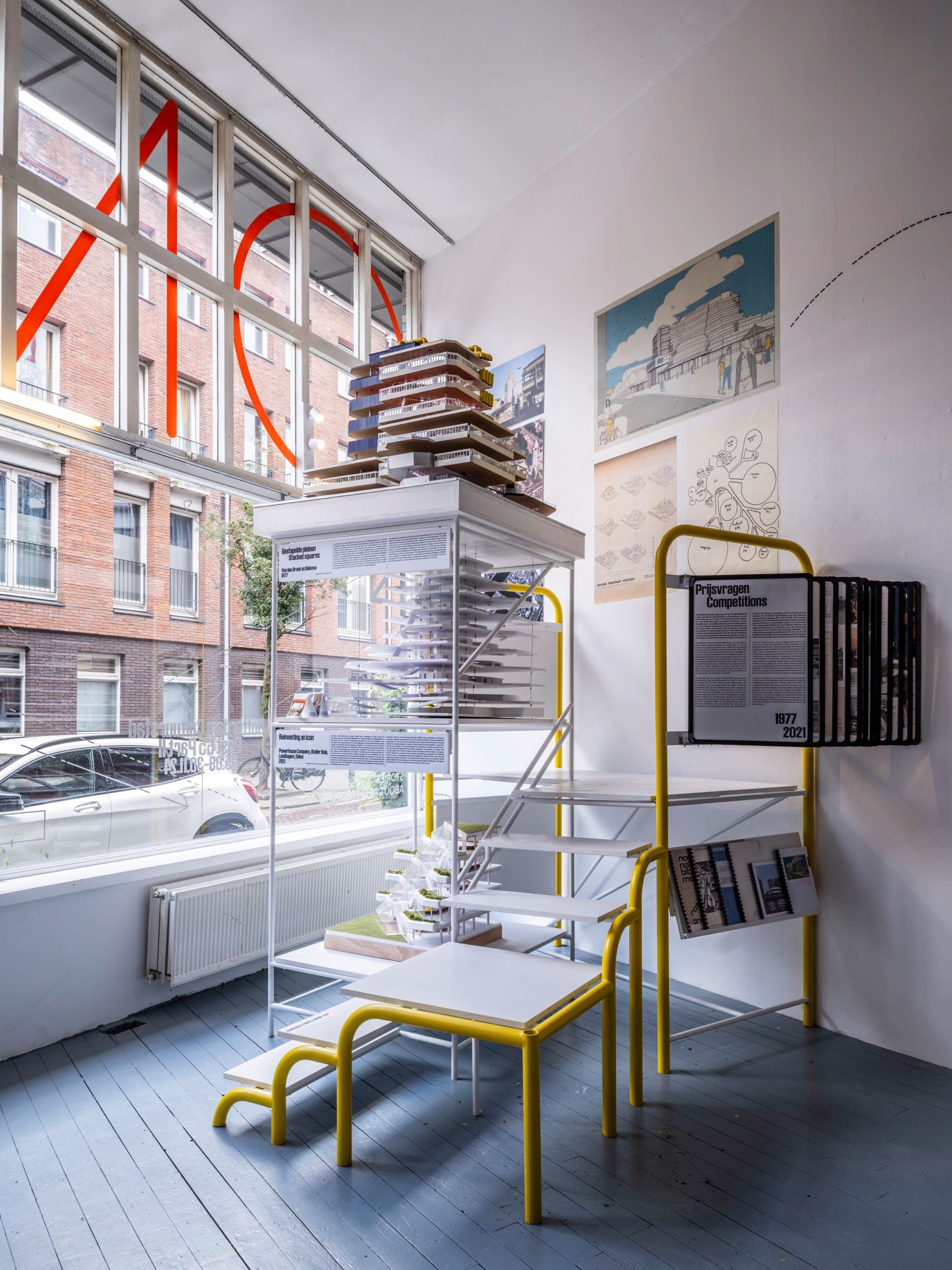 Exhibition installation with three layers of architectural models of the Central Library Rotterdam, accessible by staircase