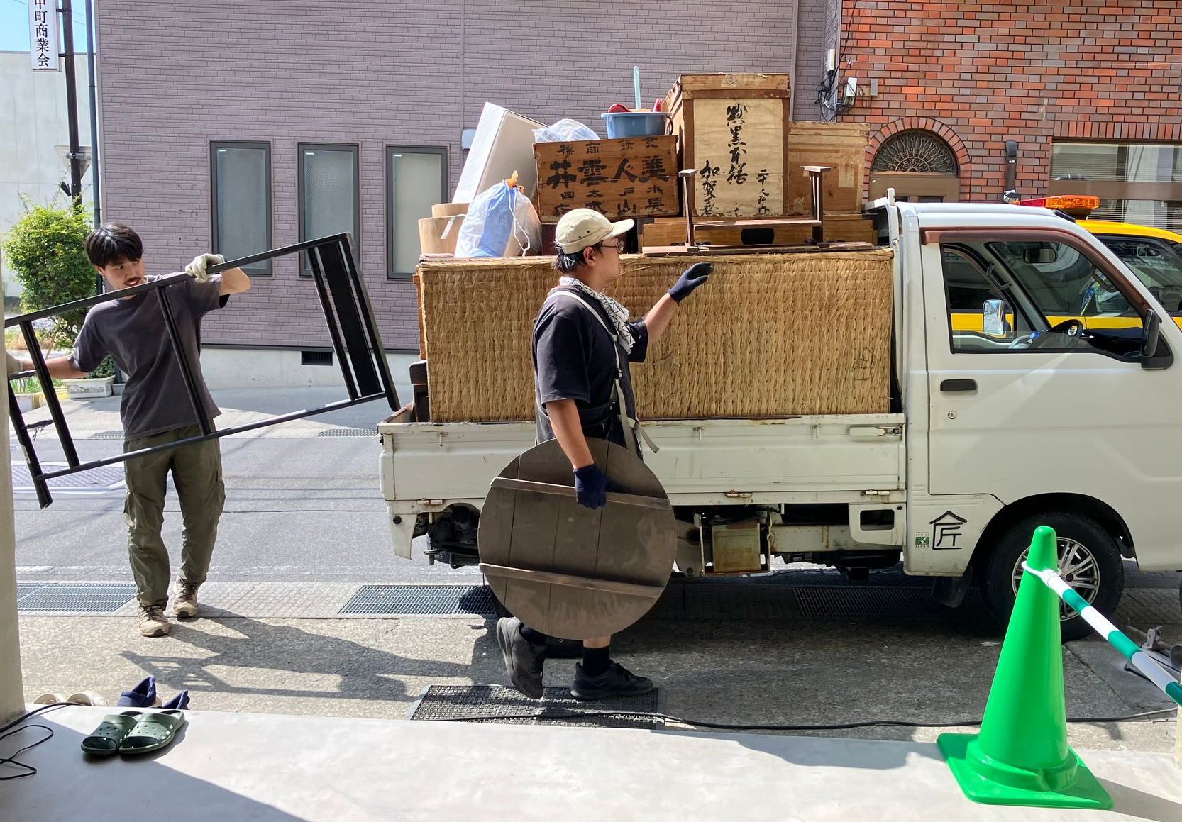 Two Japanese man loading a mini van with used furniture and tatami as part of a circular demolition process