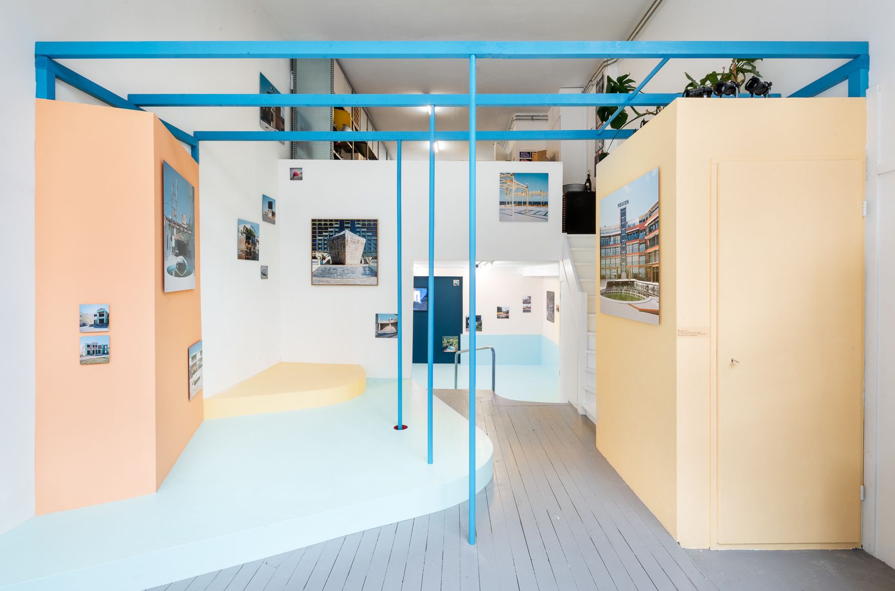 Blue pergola-esque installation, on top of a blue and yellow stage