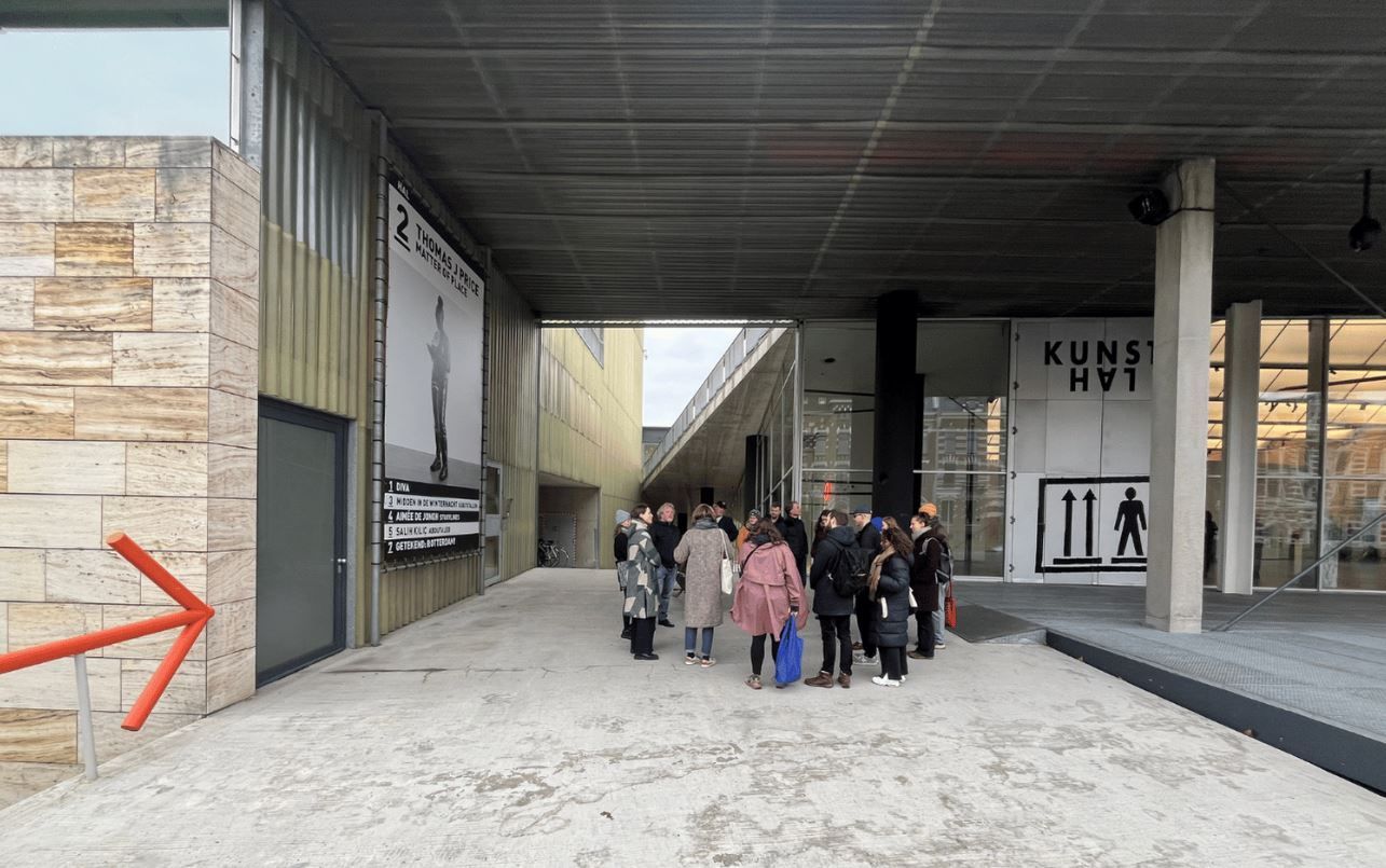 A group of people following the architectural tour at Kunsthal Rotterdam, standing in front of the building