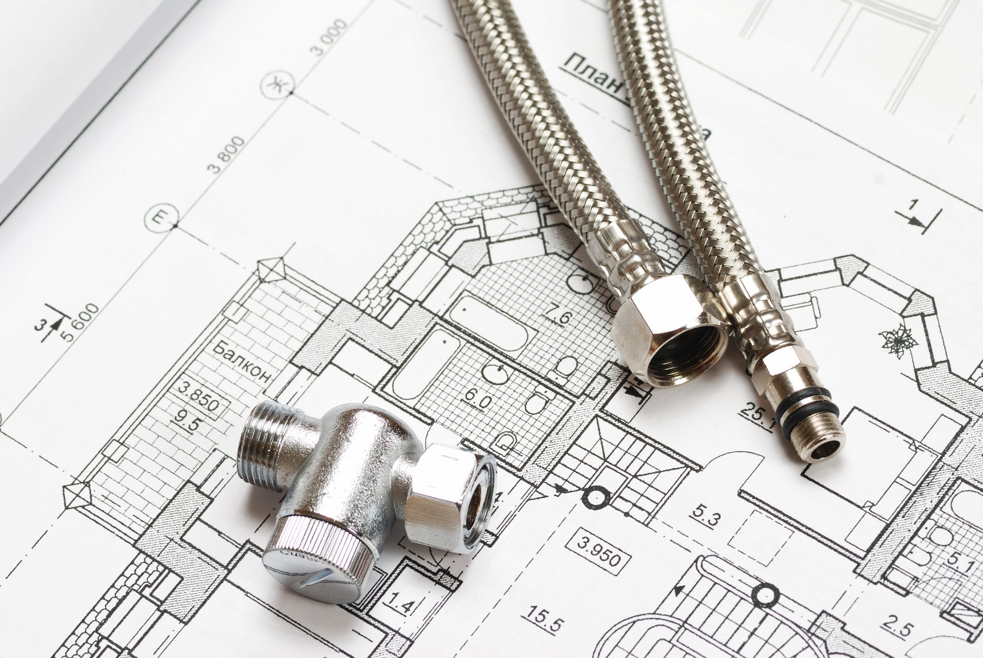 Componenti idraulici (tubi flessibili e valvola) sopra un progetto di costruzione.